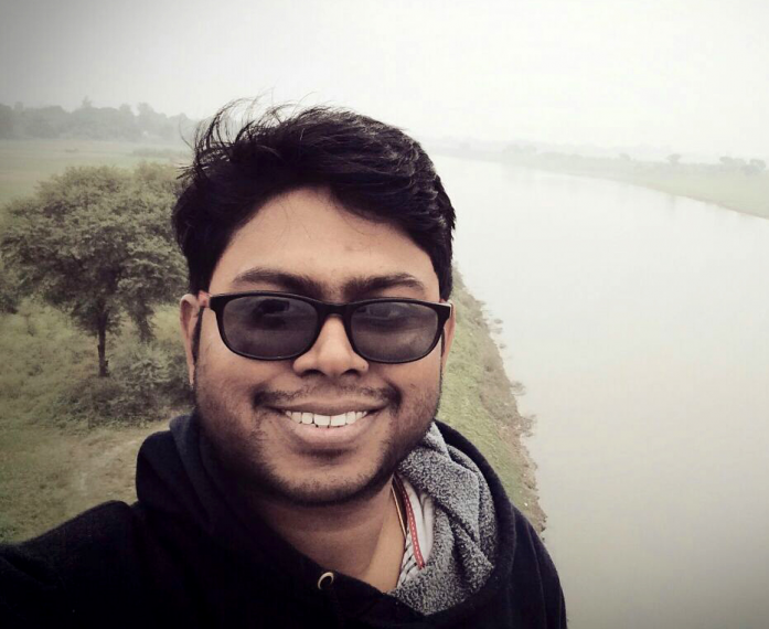 Headshot of Dr. Ashok Shaw wearing sunglasses, with a river in the background