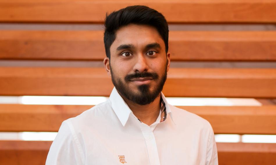 Headshot of Dr. Shadman Khan. He is standing in front of a plain background, wearing a white button up shirt. He has dark short hair, brown eyes and is looking directly at the camera.