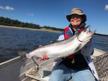 Picture of Dr. Stephenson on a boat holding a huge salmon